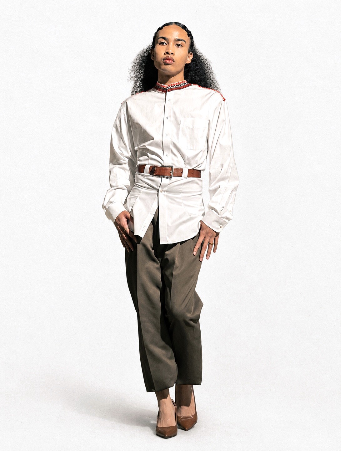 White band-collar shirt, belted, olive trousers